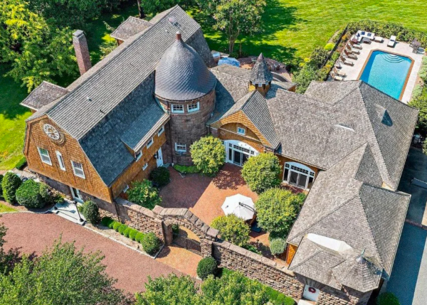 Shingle‑style waterfront cottage in Rumson with raised deck and boat slip