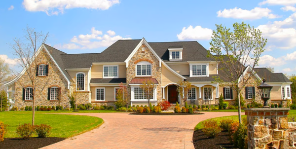 Glen Rock Insurance agent inspecting a luxury home exterior and advising on replacement cost