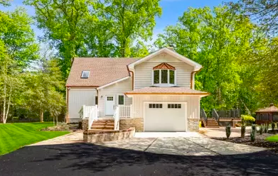 Colonial Cranbury residence with wraparound porch and mature trees