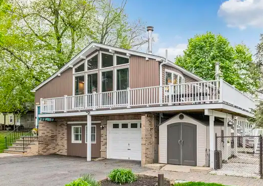 Wooded West Milford residence with detached garage and gravel driveway